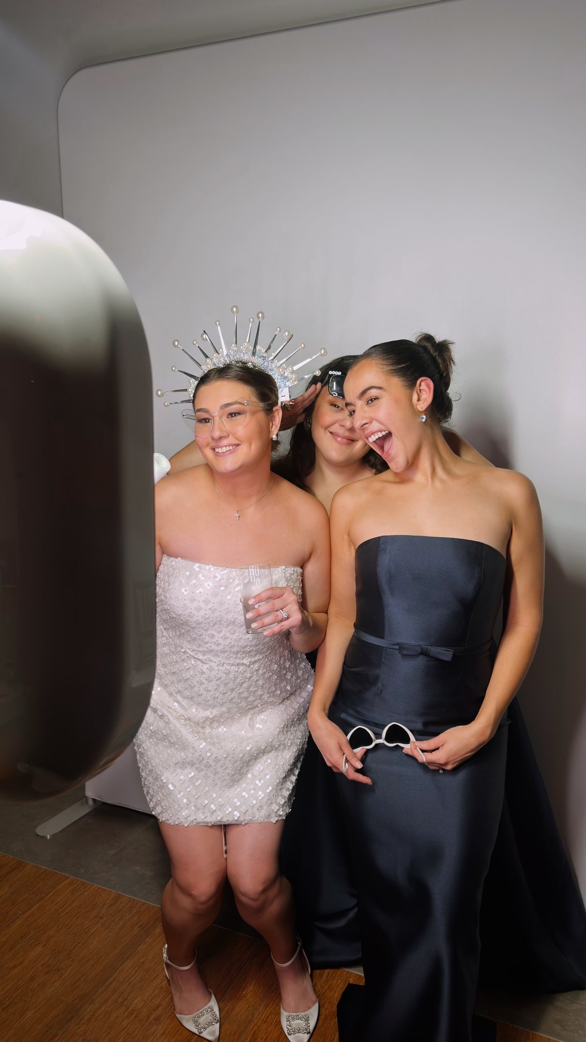 Bride in a pearl crown laughing with friends at a Snap Happy photo booth rental in South Florida